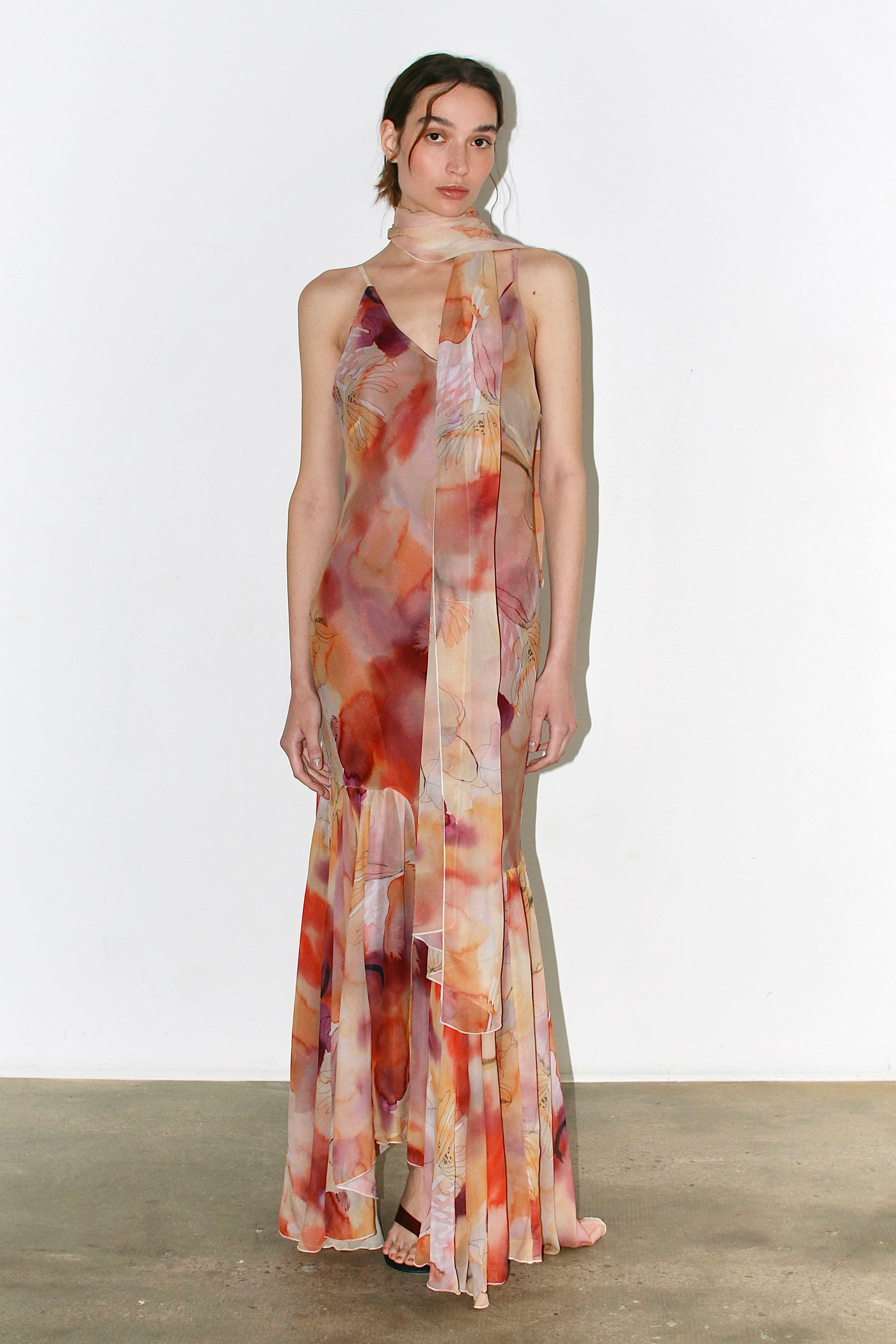 Front view of the Alma Dress in soft pink and orange abstract floral print, featuring thin adjustable straps and a flounced hem.