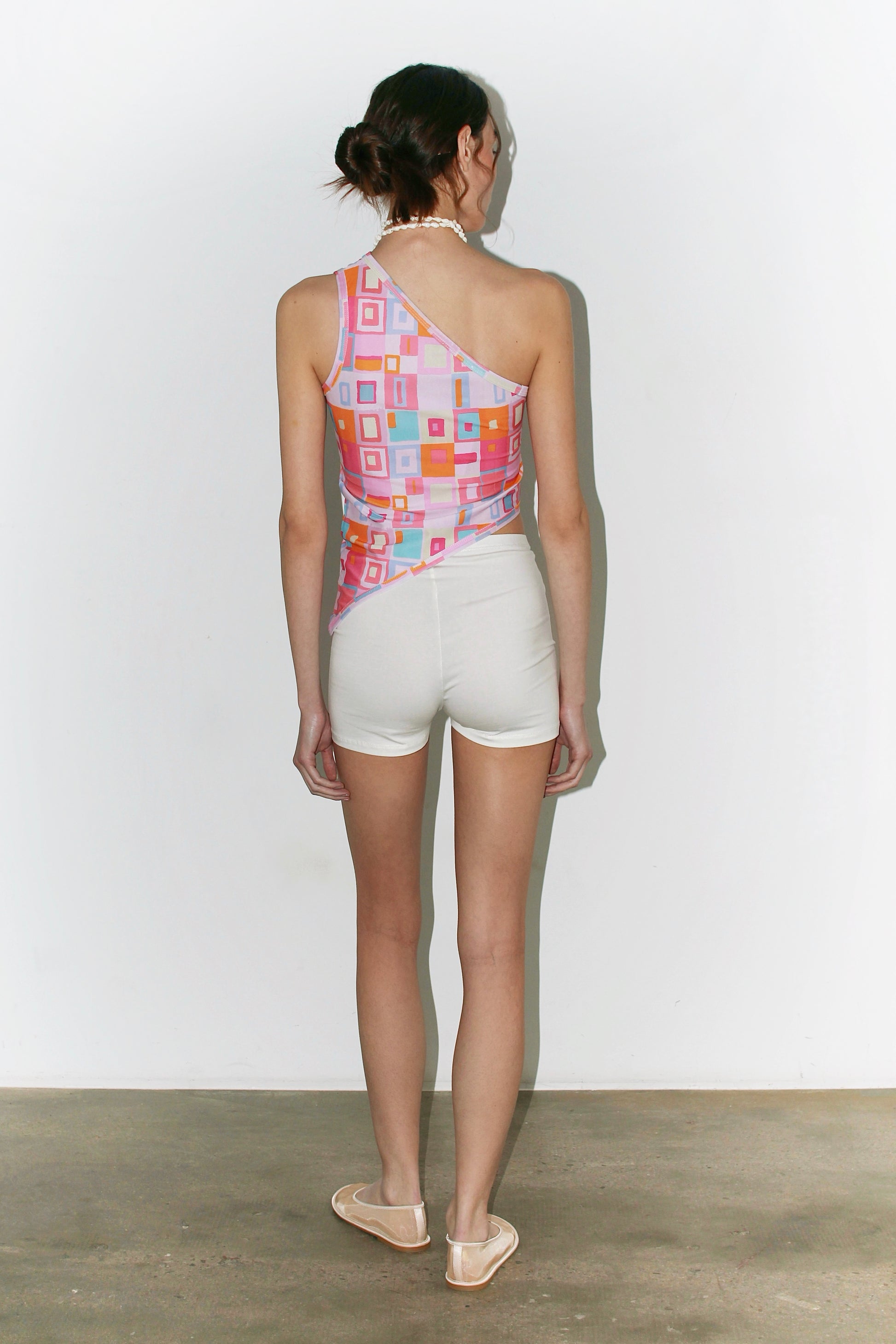 Three-quarter front view of the Laura Top – vibrant multicolor print, fitted cut and summery silhouette.