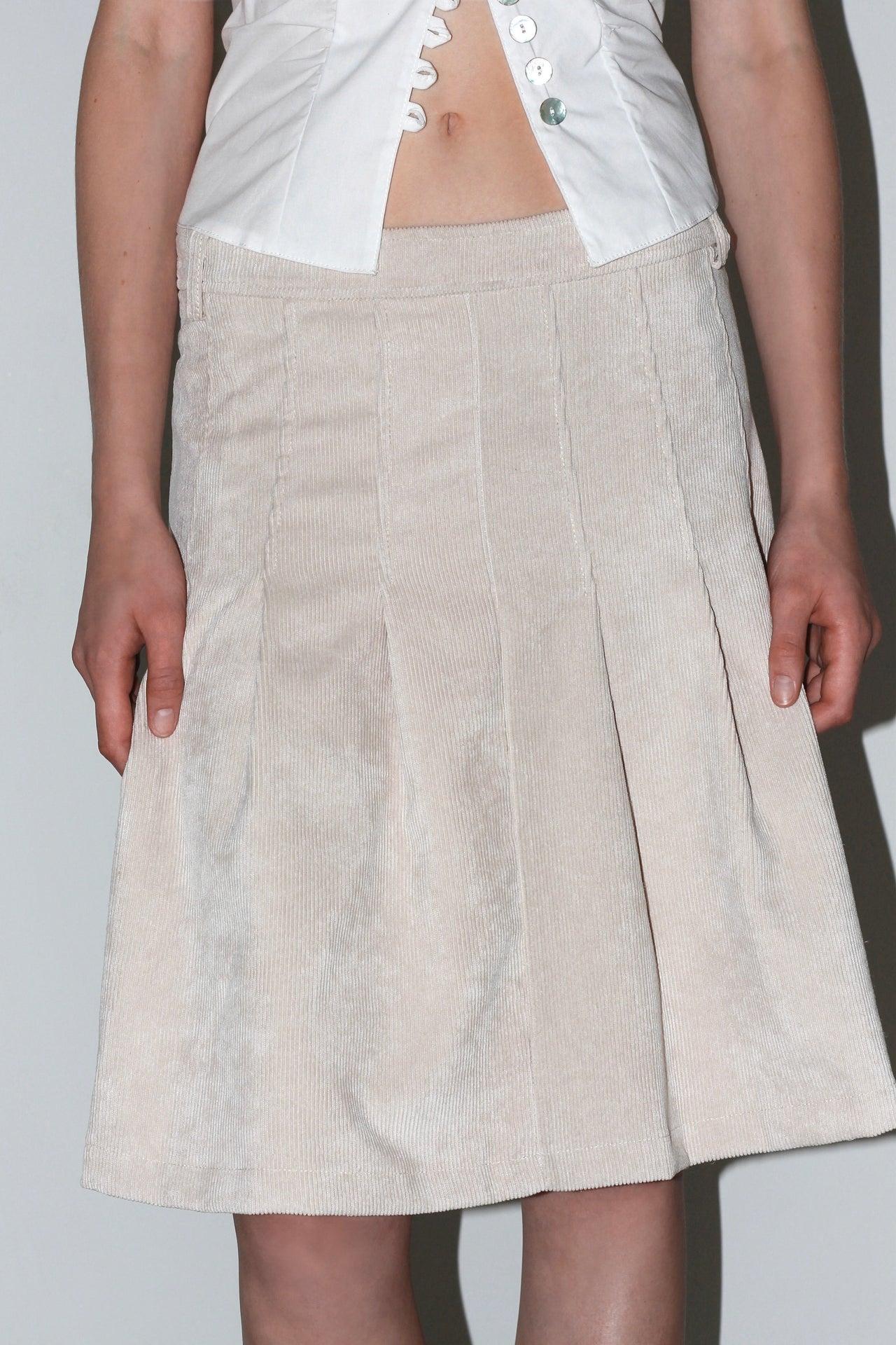 Front view of the Evie Skirt – cream-colored mini skirt with layered ruffles and high waist.
