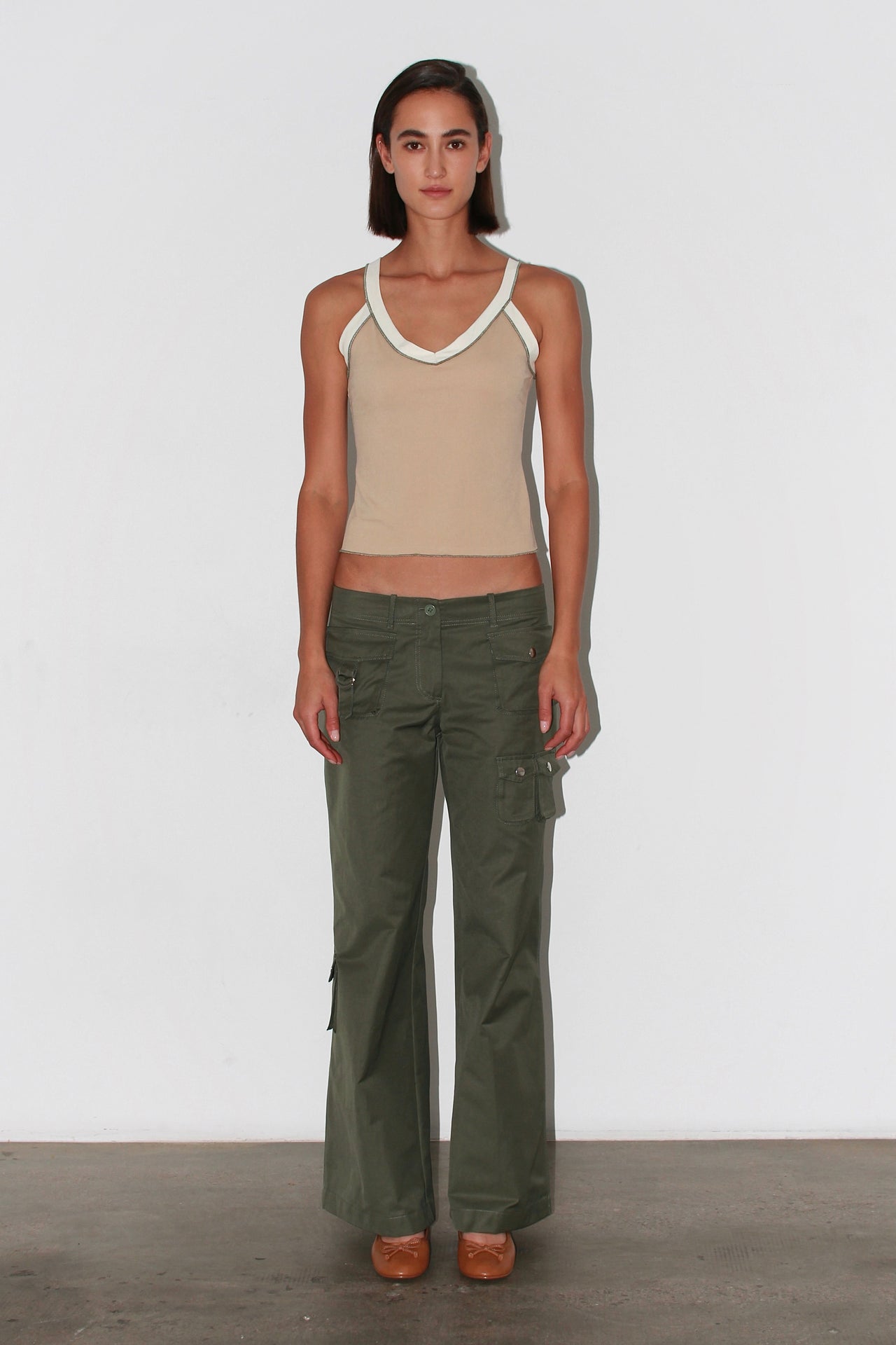 Front view of the Nat Top – beige sleeveless knit top with asymmetric neckline and fitted silhouette.