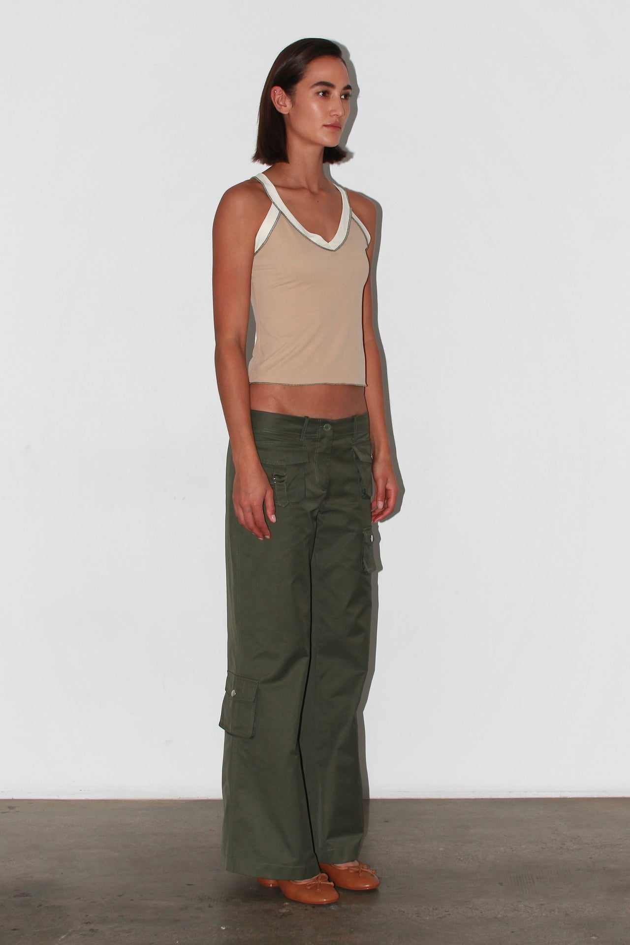 Front view of the Nat Top – beige sleeveless knit top with asymmetric neckline and fitted silhouette.