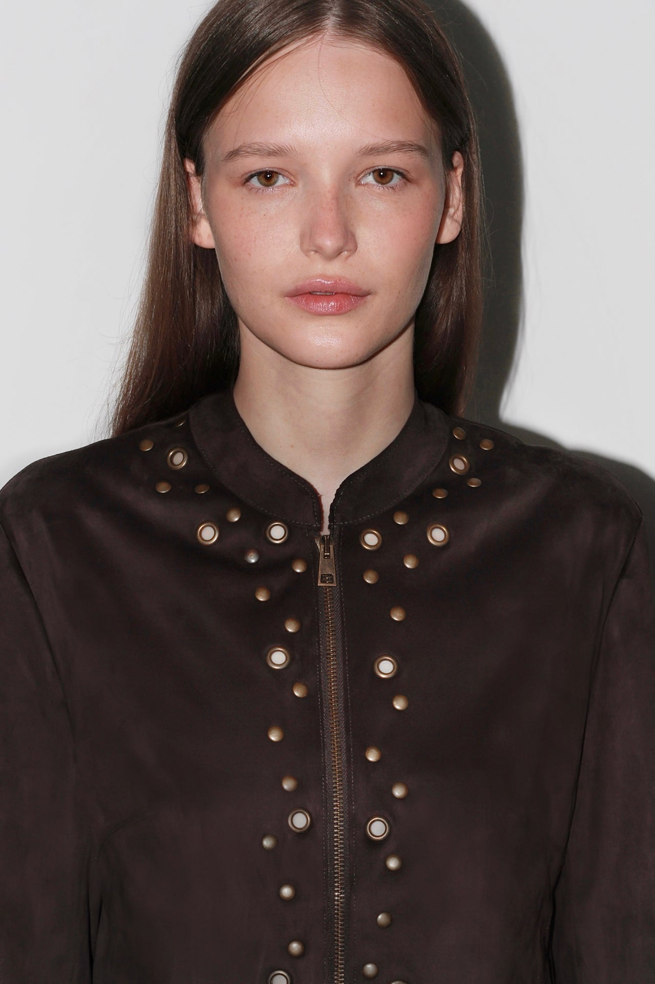 Front view of the Bella Brown Jacket – structured dark brown jacket with gold buttons and high collar.