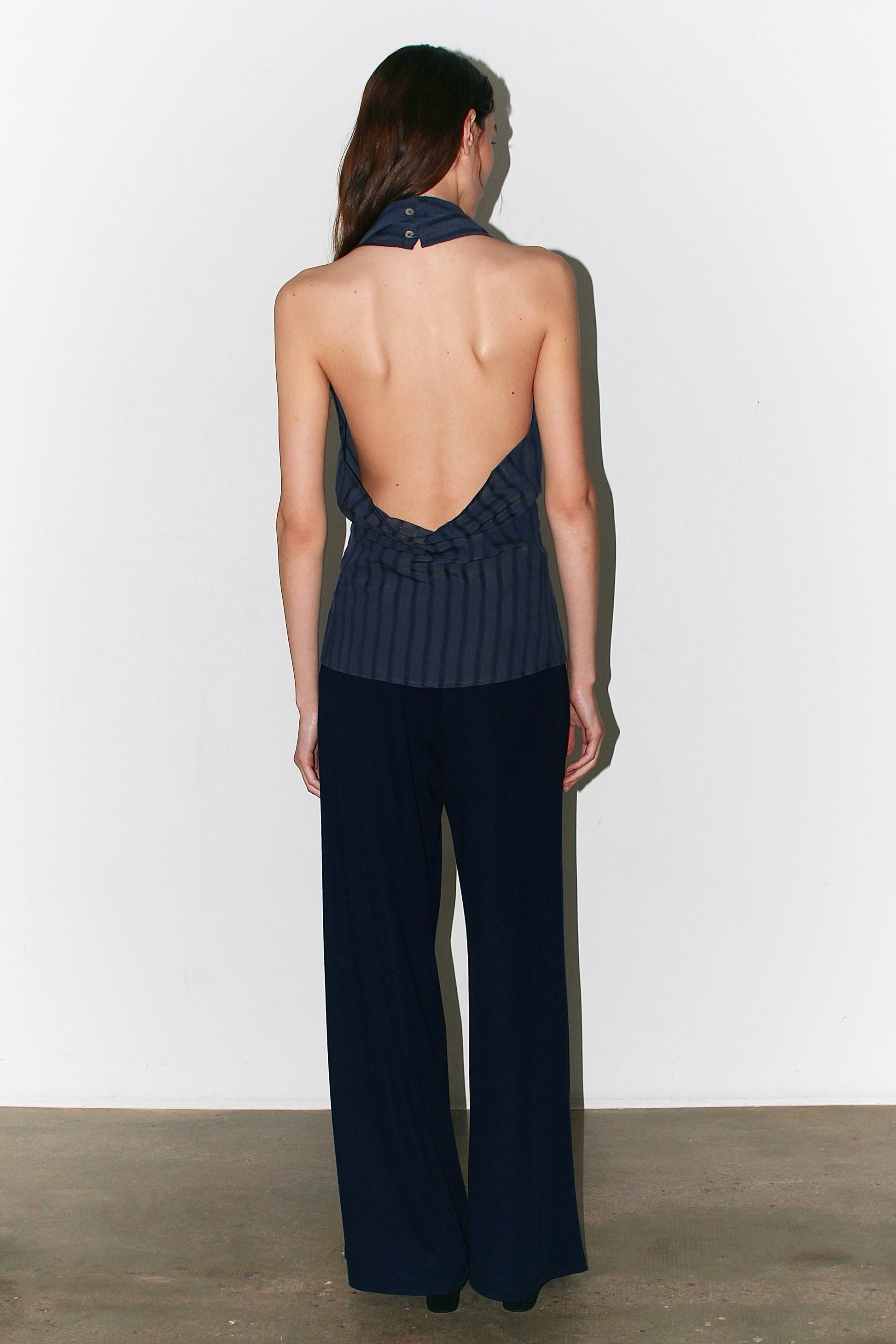 Three-quarter back view – halter neckline and open back, modern and effortless Coloma’s style.