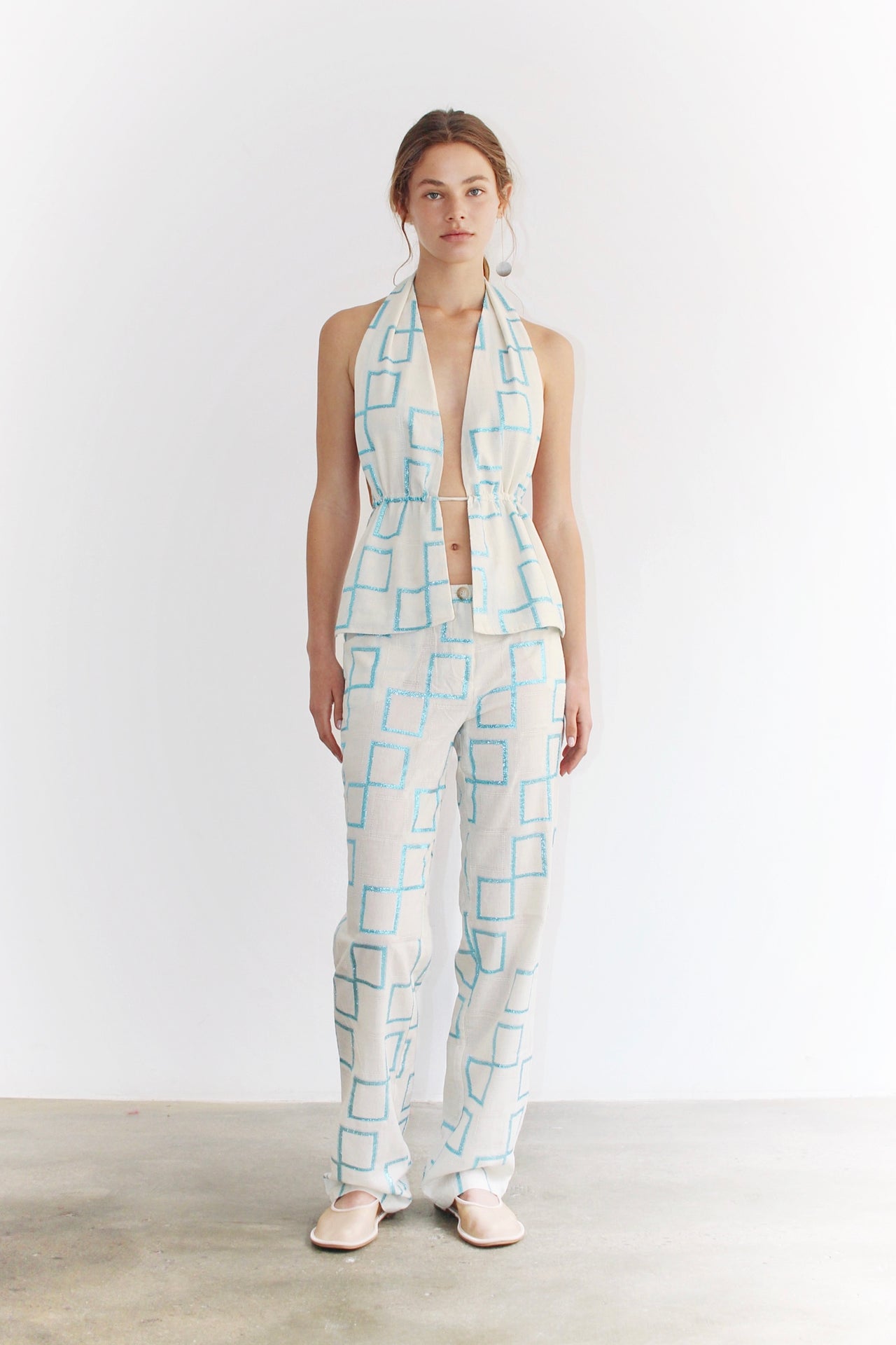 Front view of the Sveva Blue Top – light blue halter top with artistic Coloma’s print, fitted cut and modern silhouette, paired with matching pants.