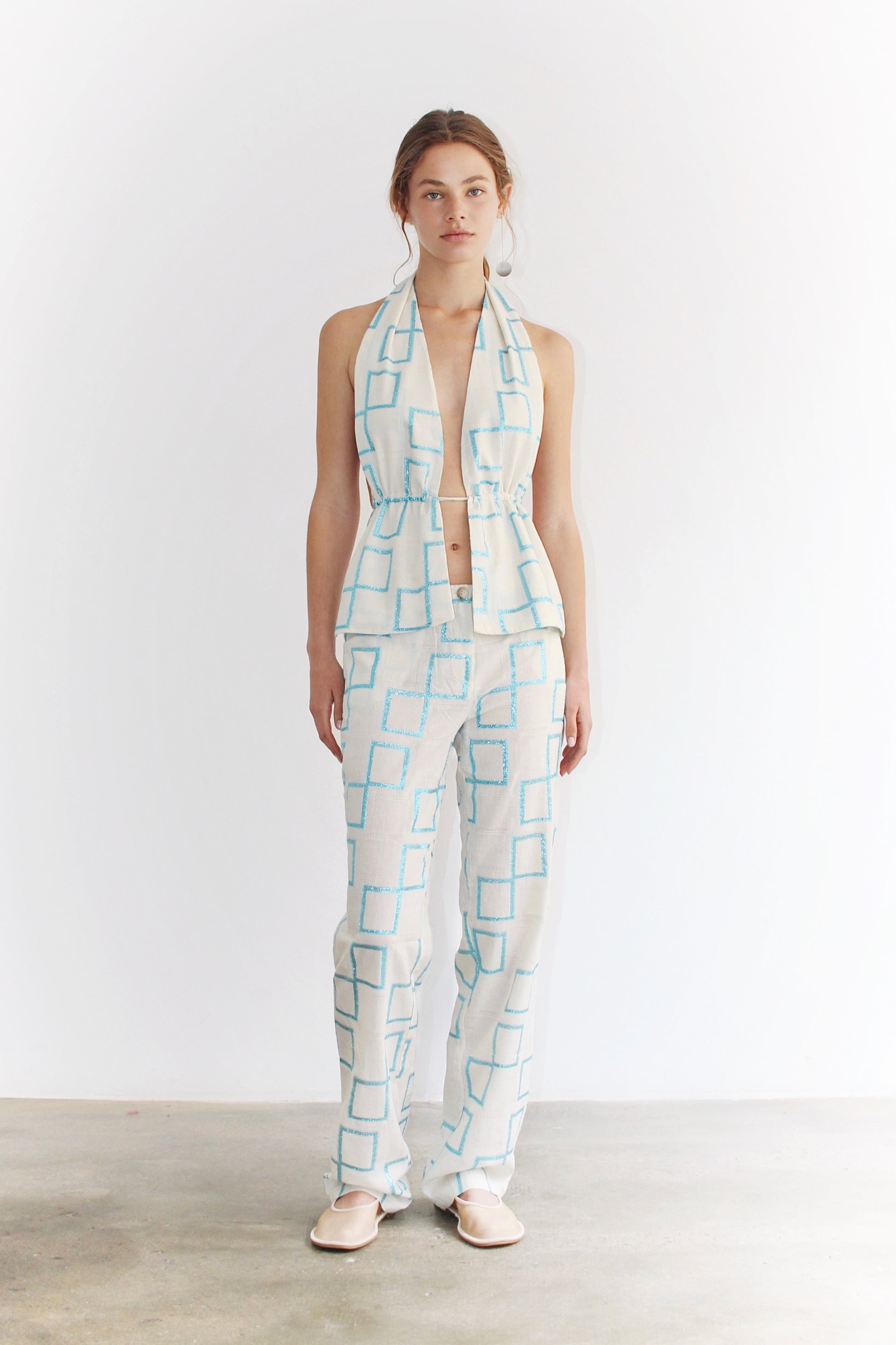 Front view of the Sveva Blue Top – light blue halter top with artistic Coloma’s print, fitted cut and modern silhouette, paired with matching pants.