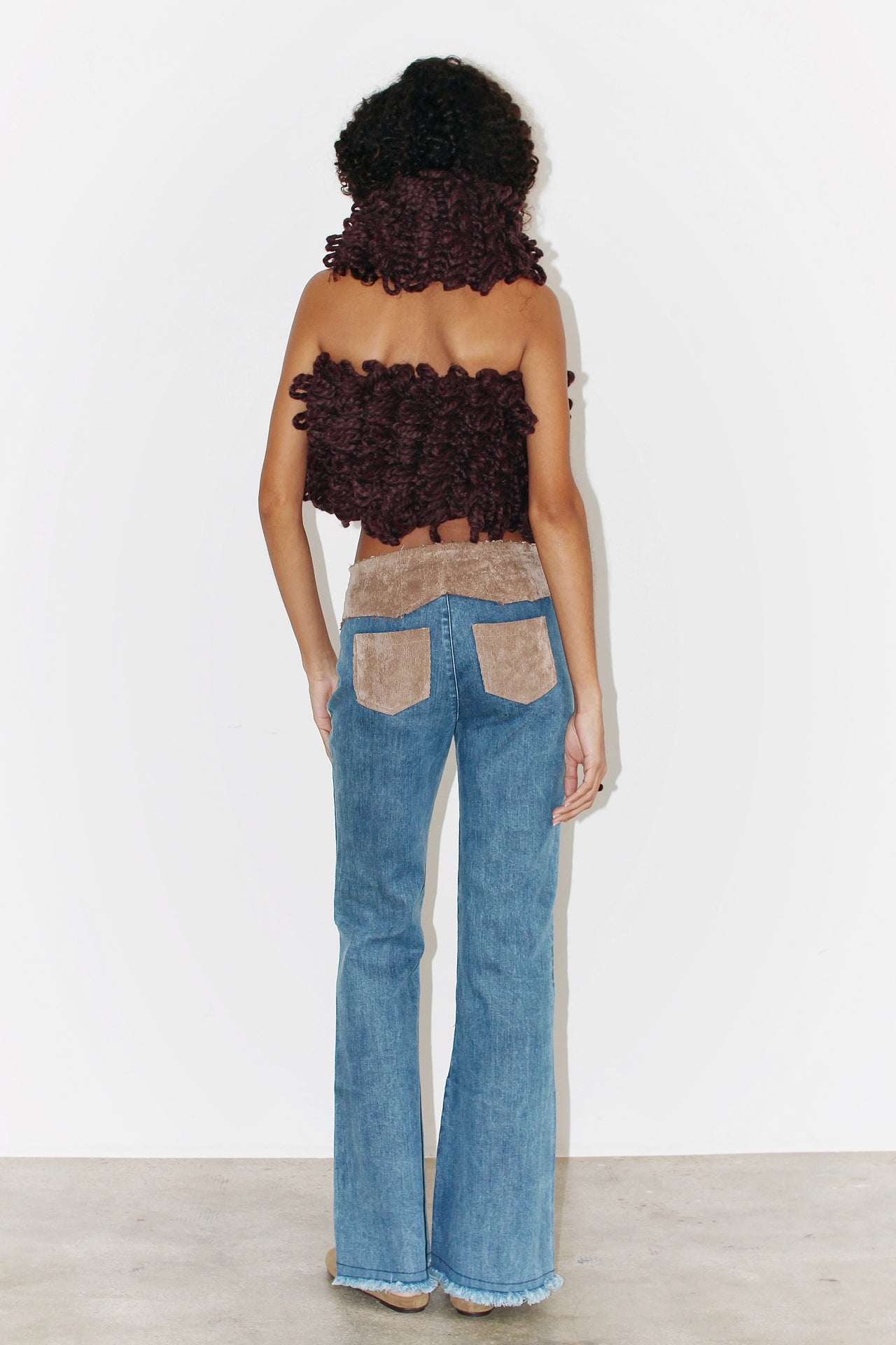 Front view of the Kika Pants – light blue denim pants with a fitted waist and straight leg cut, paired with a brown top.