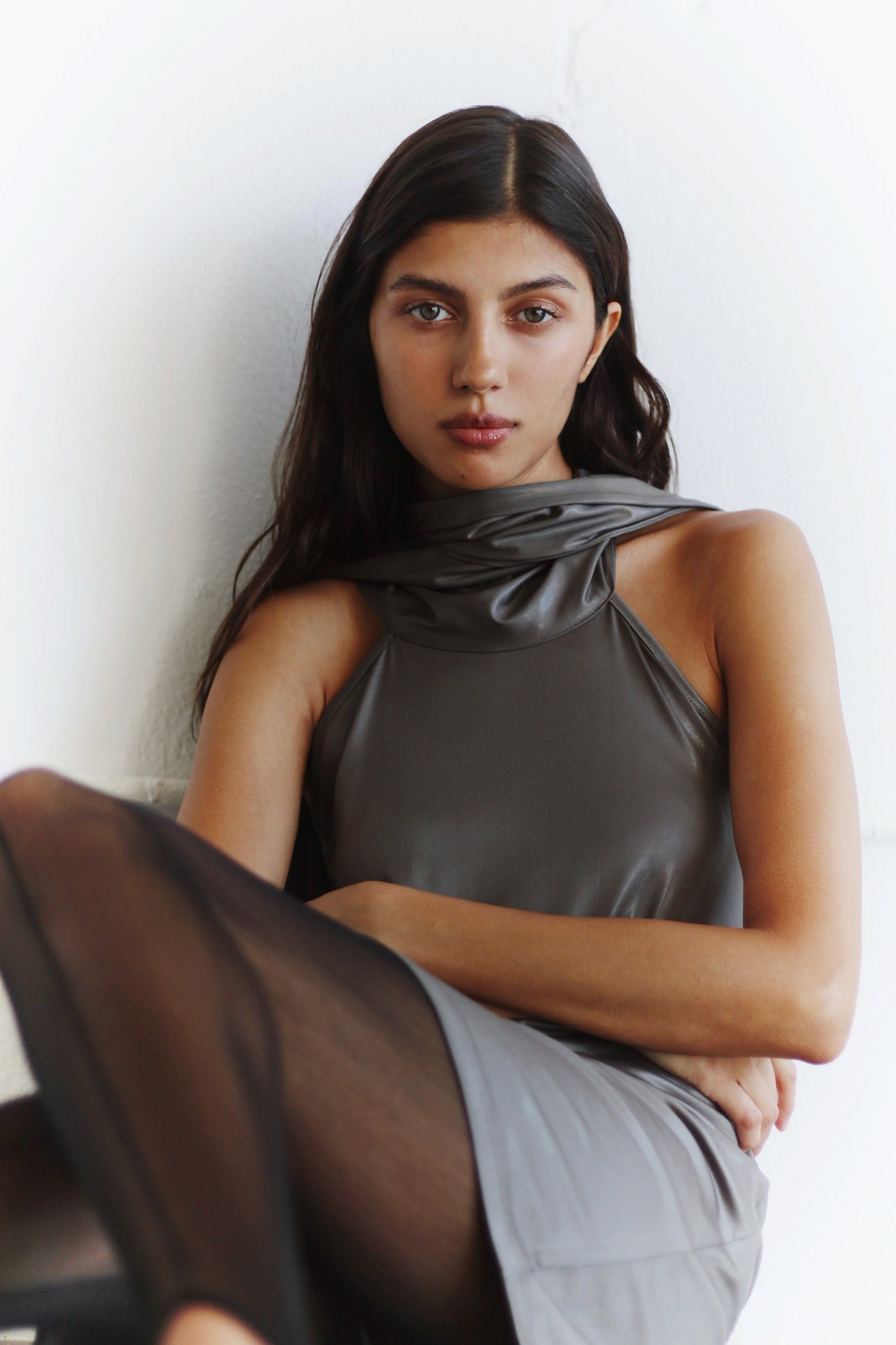 Lifestyle shot – woman sitting in the Arianna Dress, sophisticated and refined attitude.