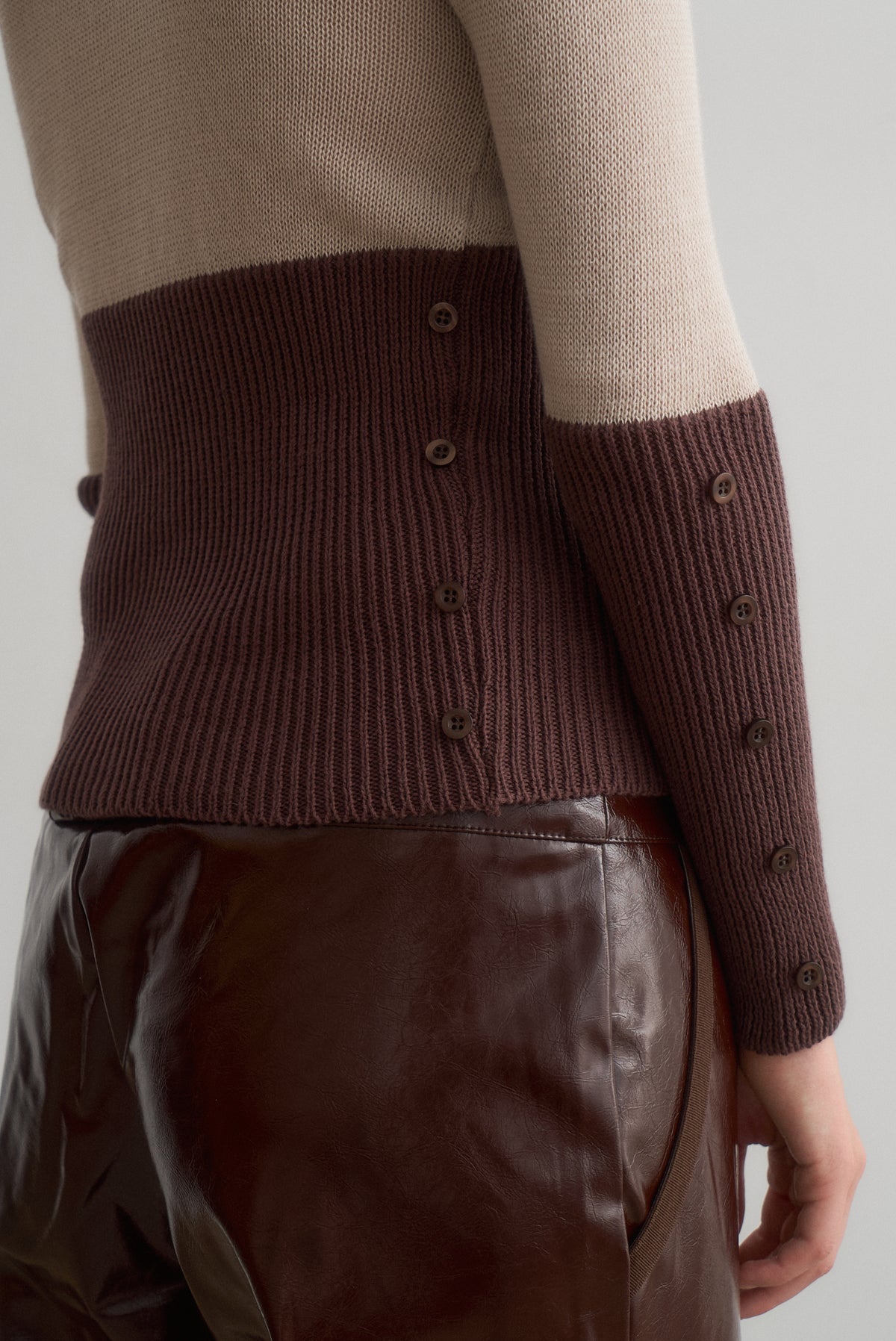 Close-up of Martita's brown ribbed waist and cuff buttons above the waistband of Montana brown trousers.