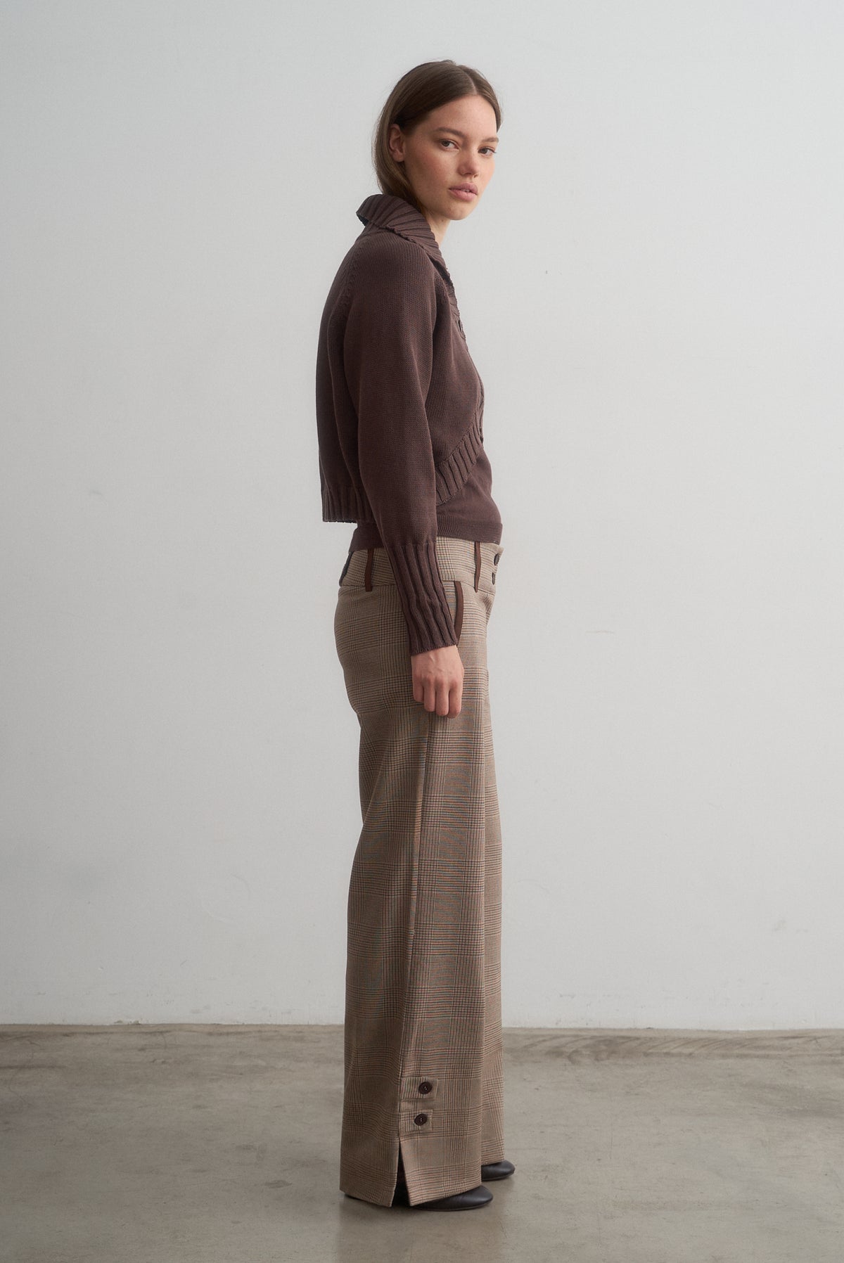 Full-length side view of Carlita brown knit cardigan styled with Lavinia checked wide-leg trousers.