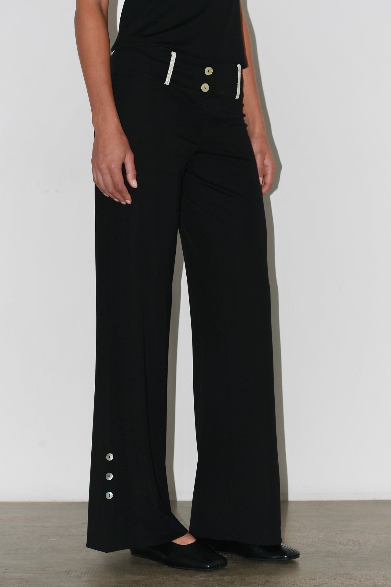 Front view of the Zeynep Pants – high-waisted black trousers with a straight and structured cut.