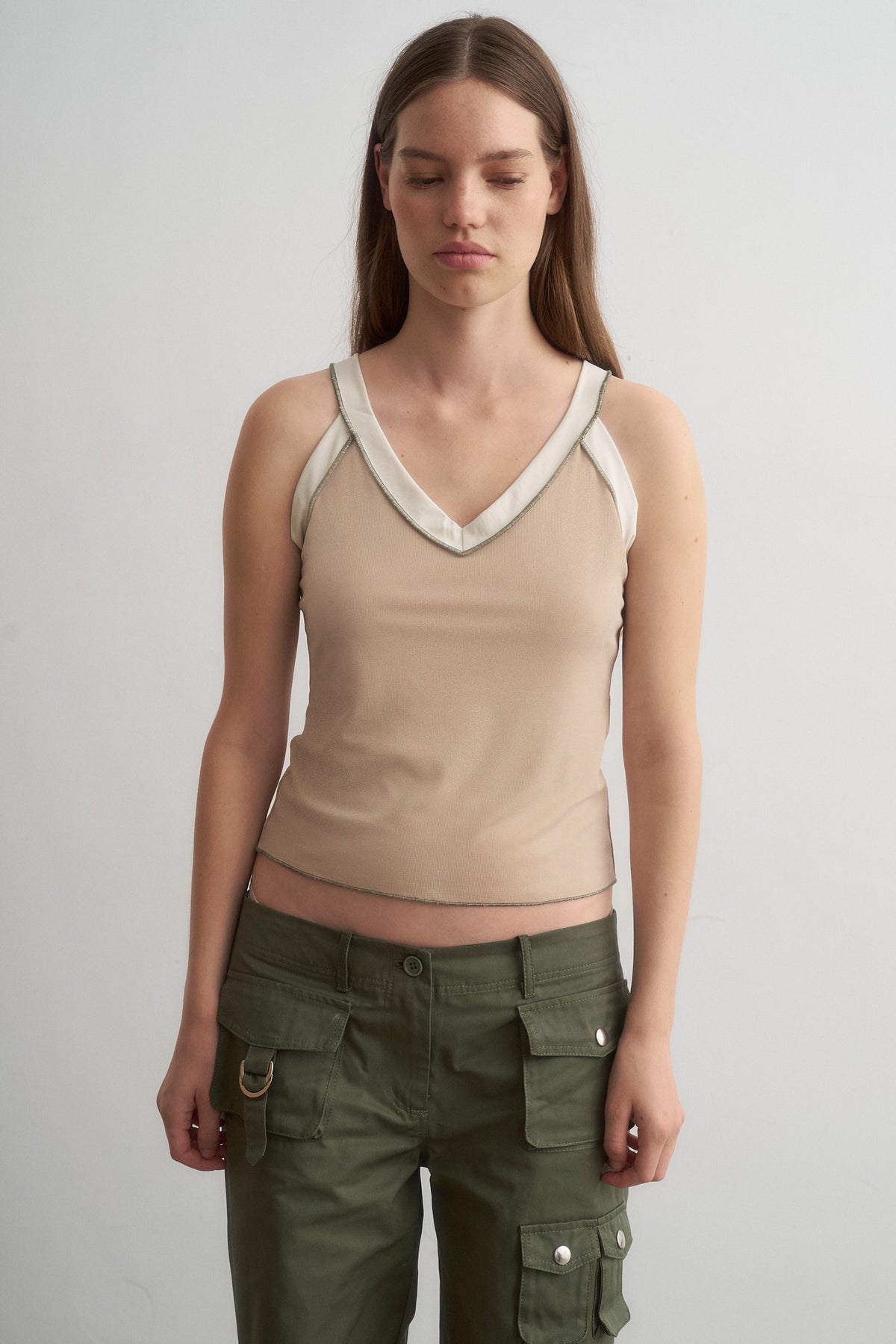 Nat beige top with ivory trim, front view of the asymmetric neckline