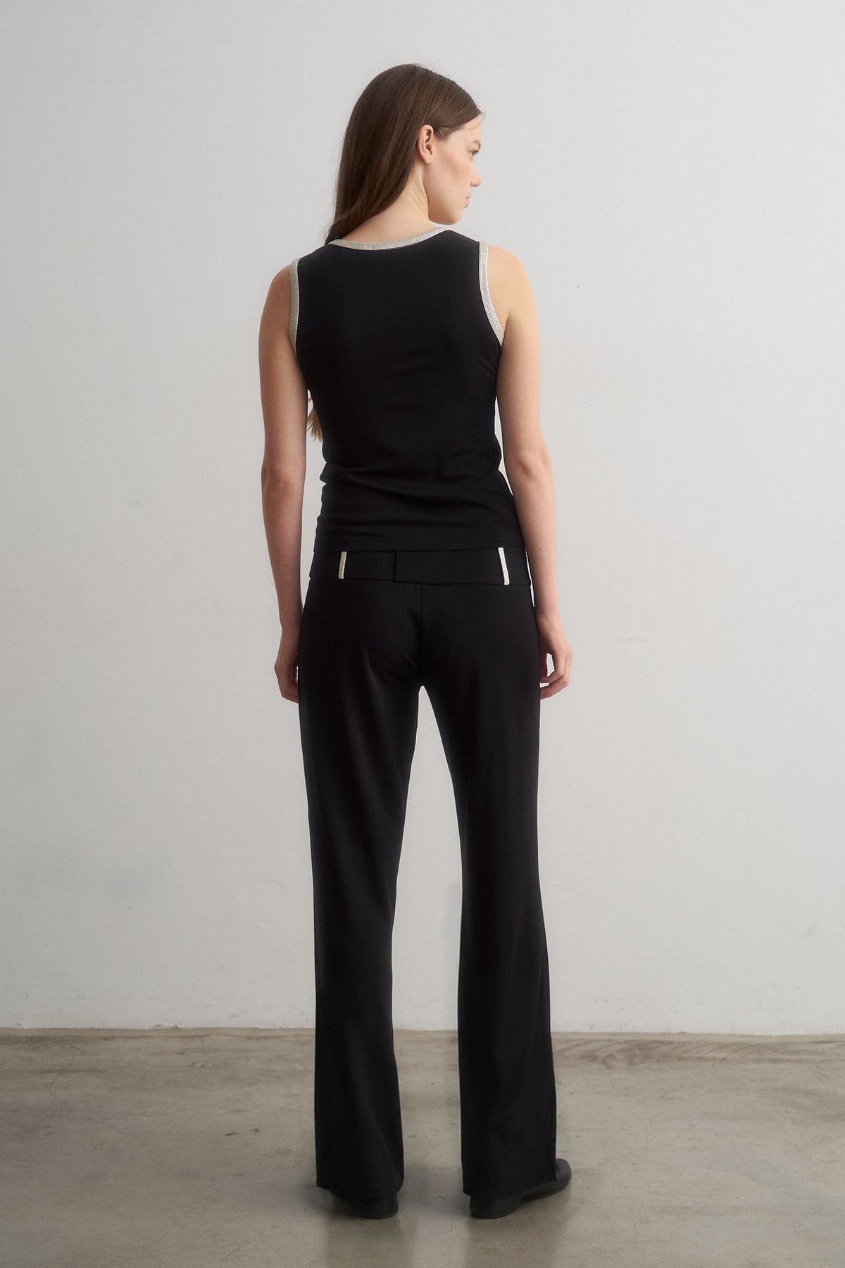 Jade black sleeveless top worn with Zeynep black trousers, full-length rear view