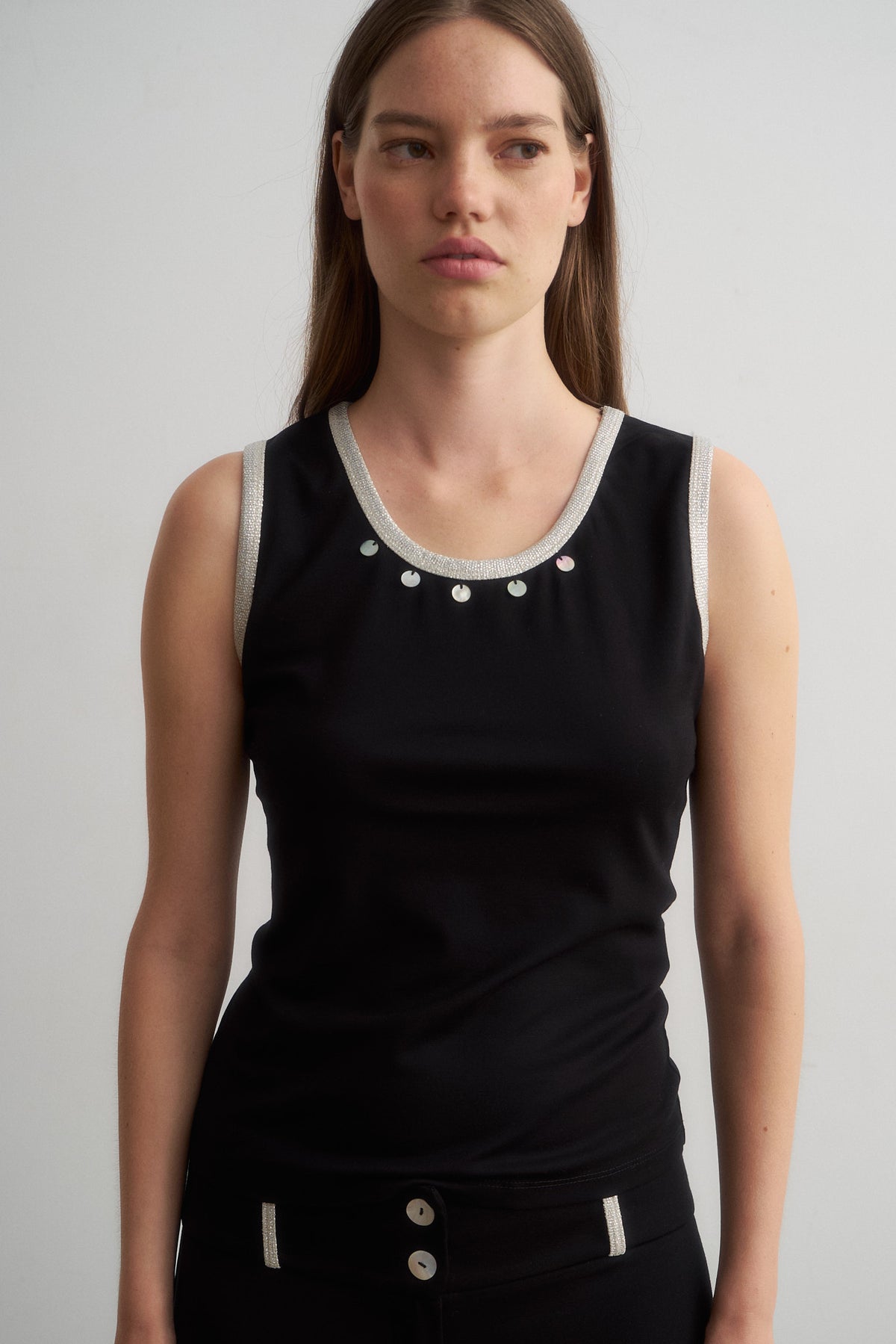 Jade black sleeveless top with metallic trim and shell details, front view
