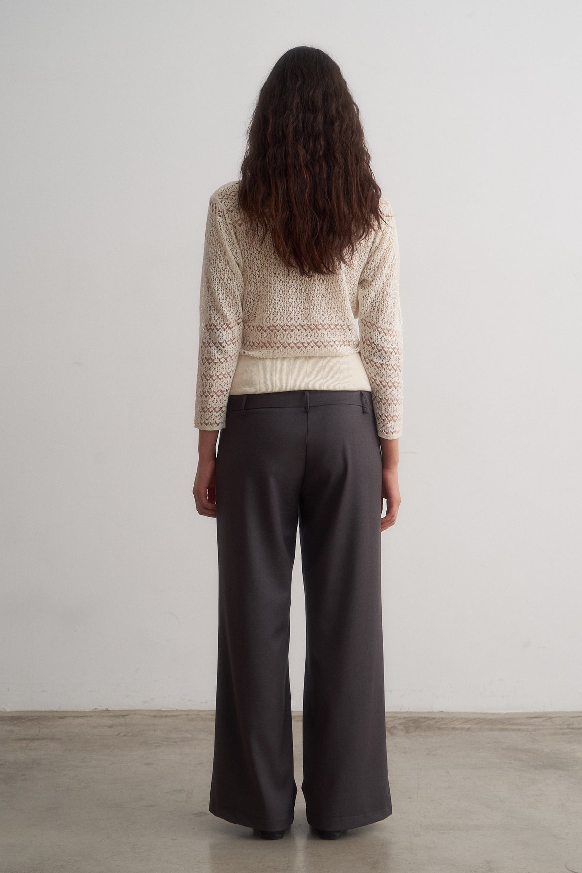 Valentina grey wide-leg trousers worn with a knit top, full-length rear view
