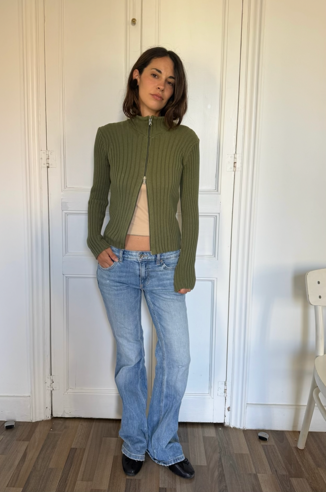 Barca green zip top worn with blue jeans, full-length front view